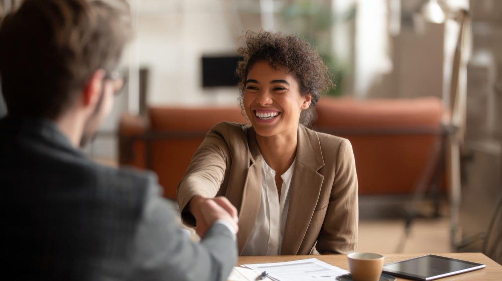 Profissional apertando a mão de candidato após entrevista de emprego.
